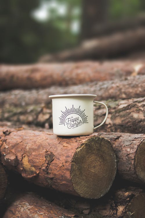 White Happy Camper-printed Cup on Brown Wooden Log