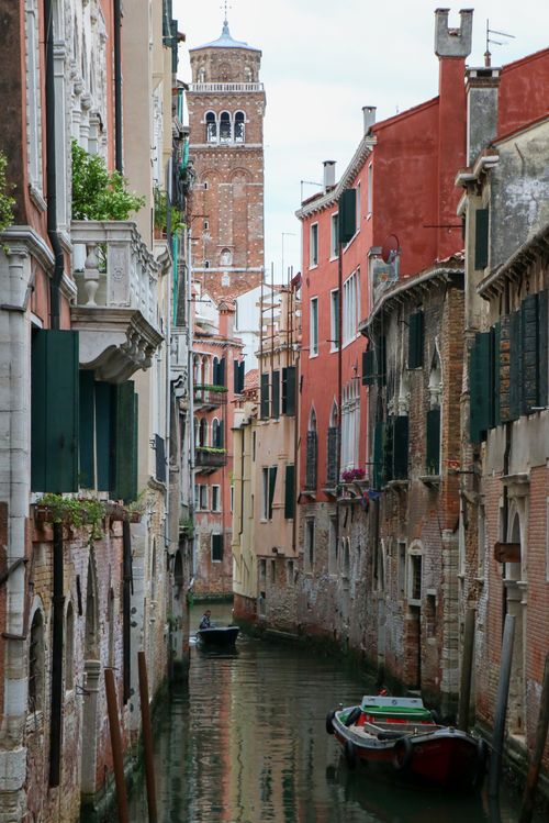 Free Charming Venice canal with gondolas and historic architecture under a calm sky. Stock Photo