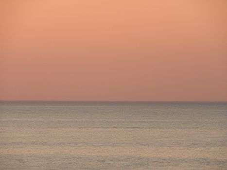 A calming view of the ocean horizon during twilight with pastel skies.
