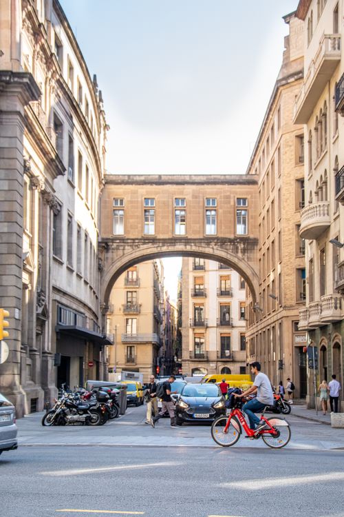 Free Busy urban street with bicycles, cars, and pedestrians near historic European architecture. Stock Photo