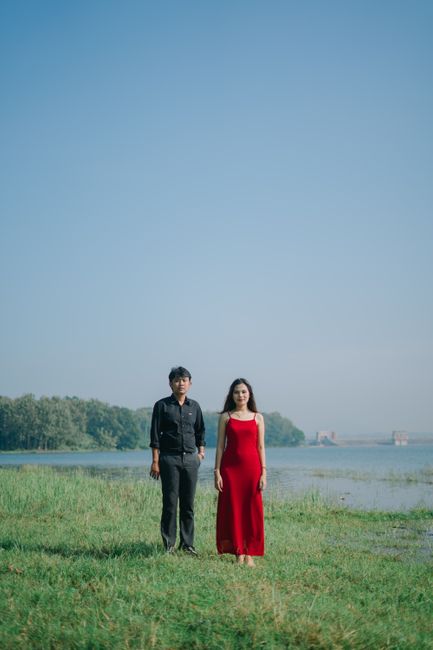 An Asian couple stands by a serene lake in Indonesia, capturing the essence of tranquility and connection.