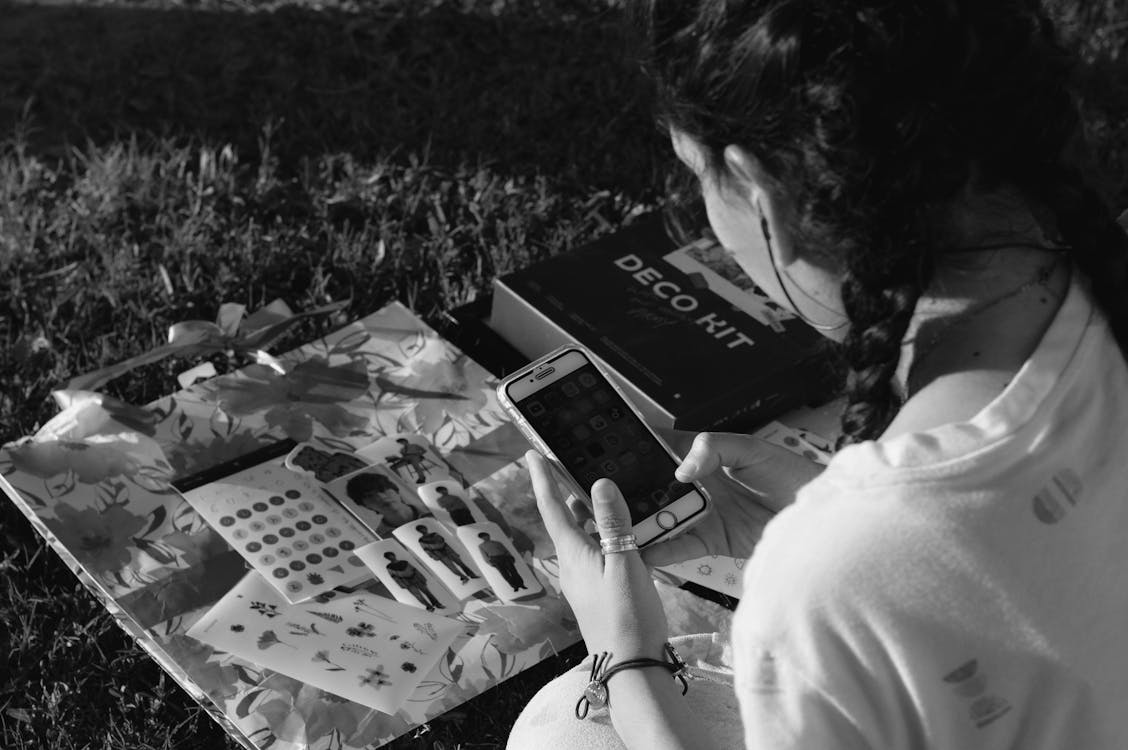 Monochrome Shot of a Woman Using a Smartphone