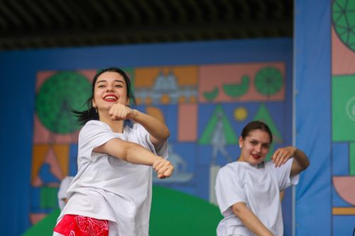 Free Energetic dancers in white shirts and red bandanas perform joyously outdoors. Stock Photo