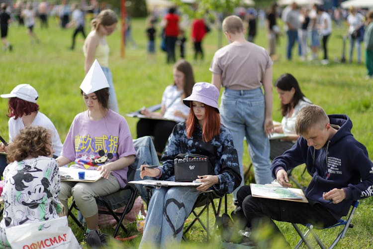 People Sitting On Chairs In A Public Park