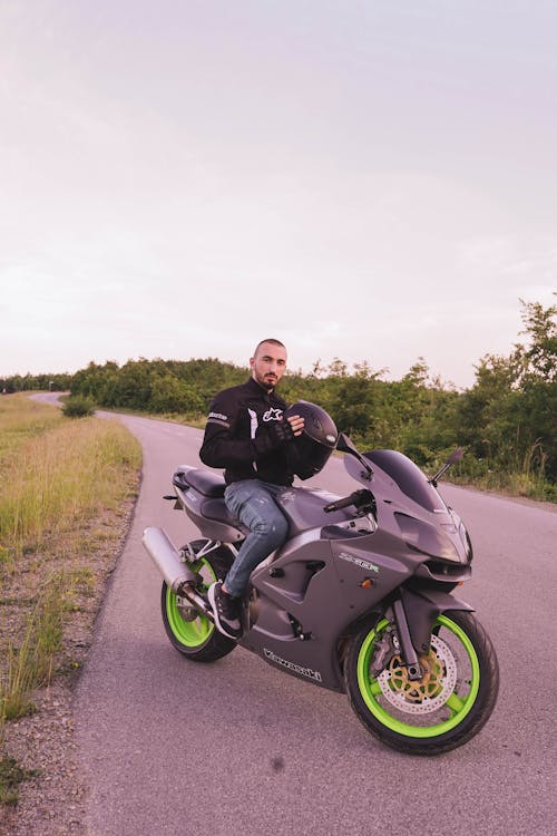 A Man in Black Jacket Riding a Black Motorcycle