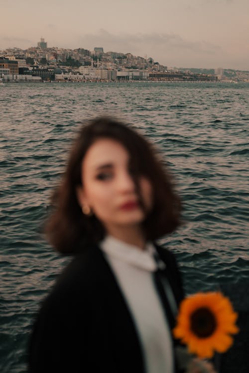 Blurry Photo of a Woman Holding Sunflower