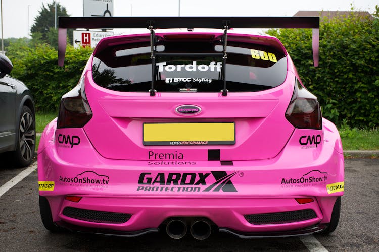 A Pink Sports Car Parked On The Road