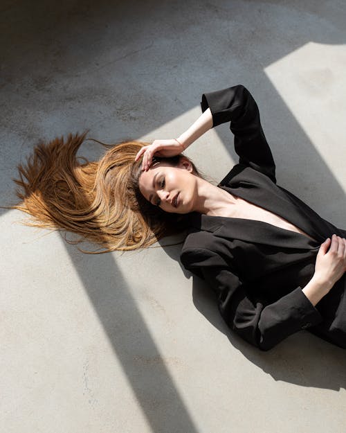 A Woman in Black Suit Lying on the Ground