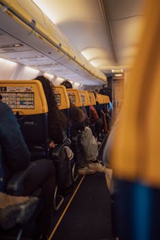 Interior view of an airplane with passengers seated in economy class, showcasing travel atmosphere.