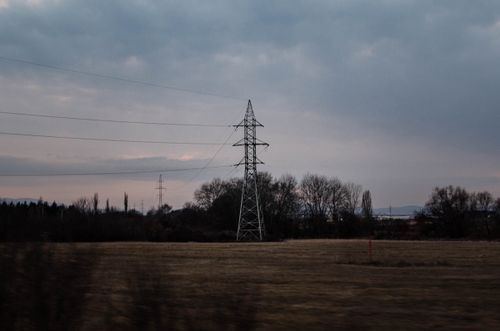 Free A serene field with an electric post under a moody dusk sky, offering a tranquil view. Stock Photo