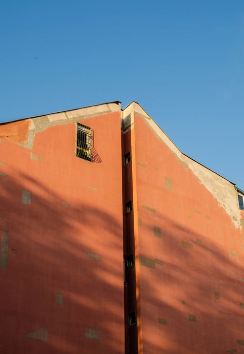 Free Close-up view of a tall building structure with a clear blue sky background, showcasing urban architecture. Stock Photo