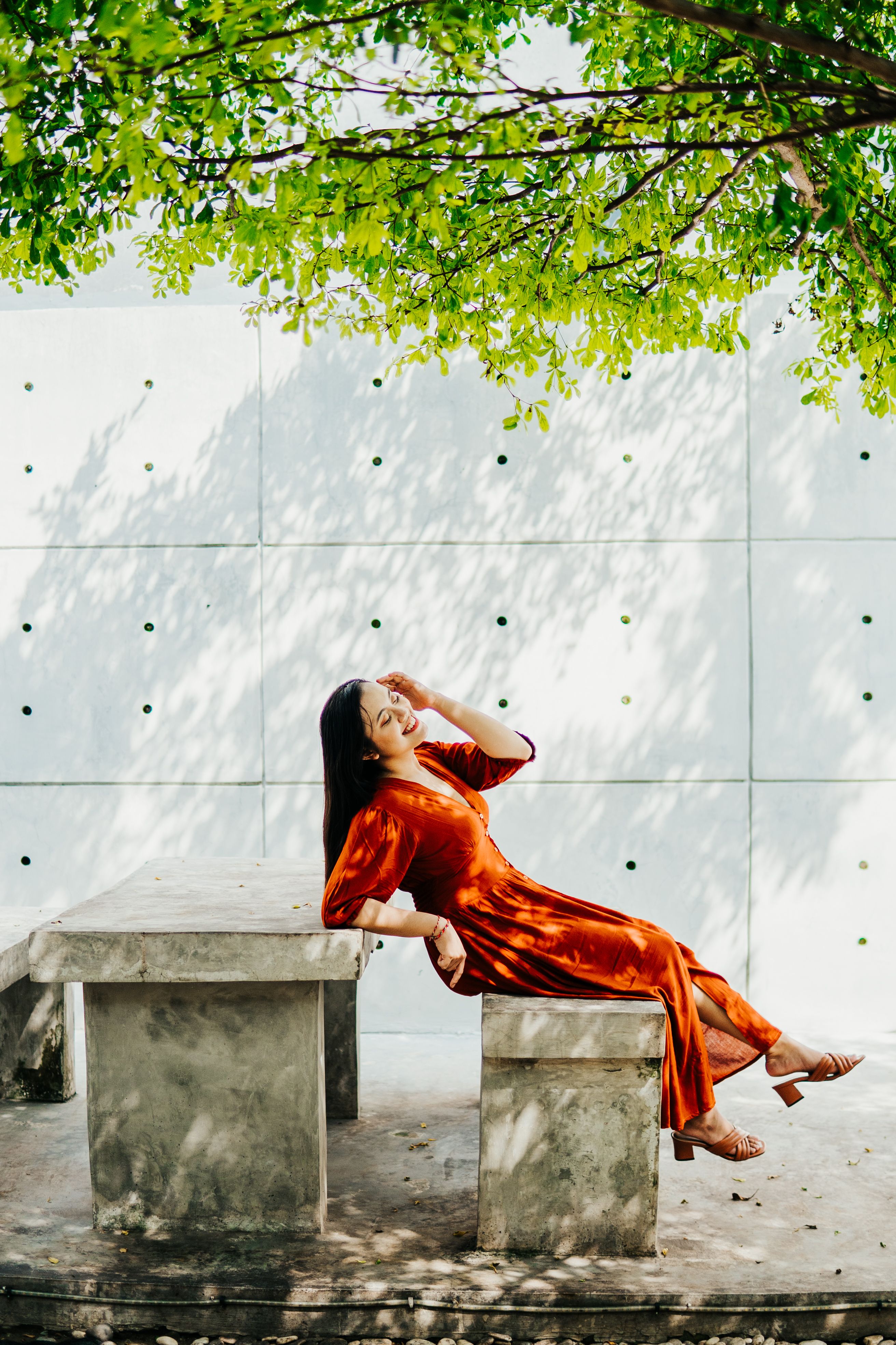 A Woman in Brown Dress Sitting on a Concrete Bench · Free Stock Photo