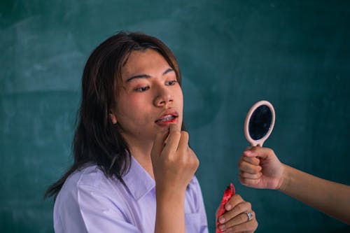 A Woman Putting Lipstick on Her Lips