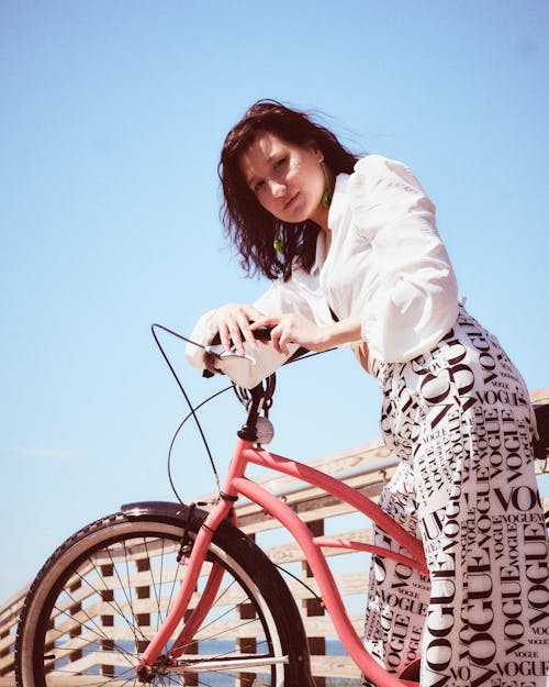 Close-Up Shot of a Woman in White Long Sleeve Riding a Bicycle