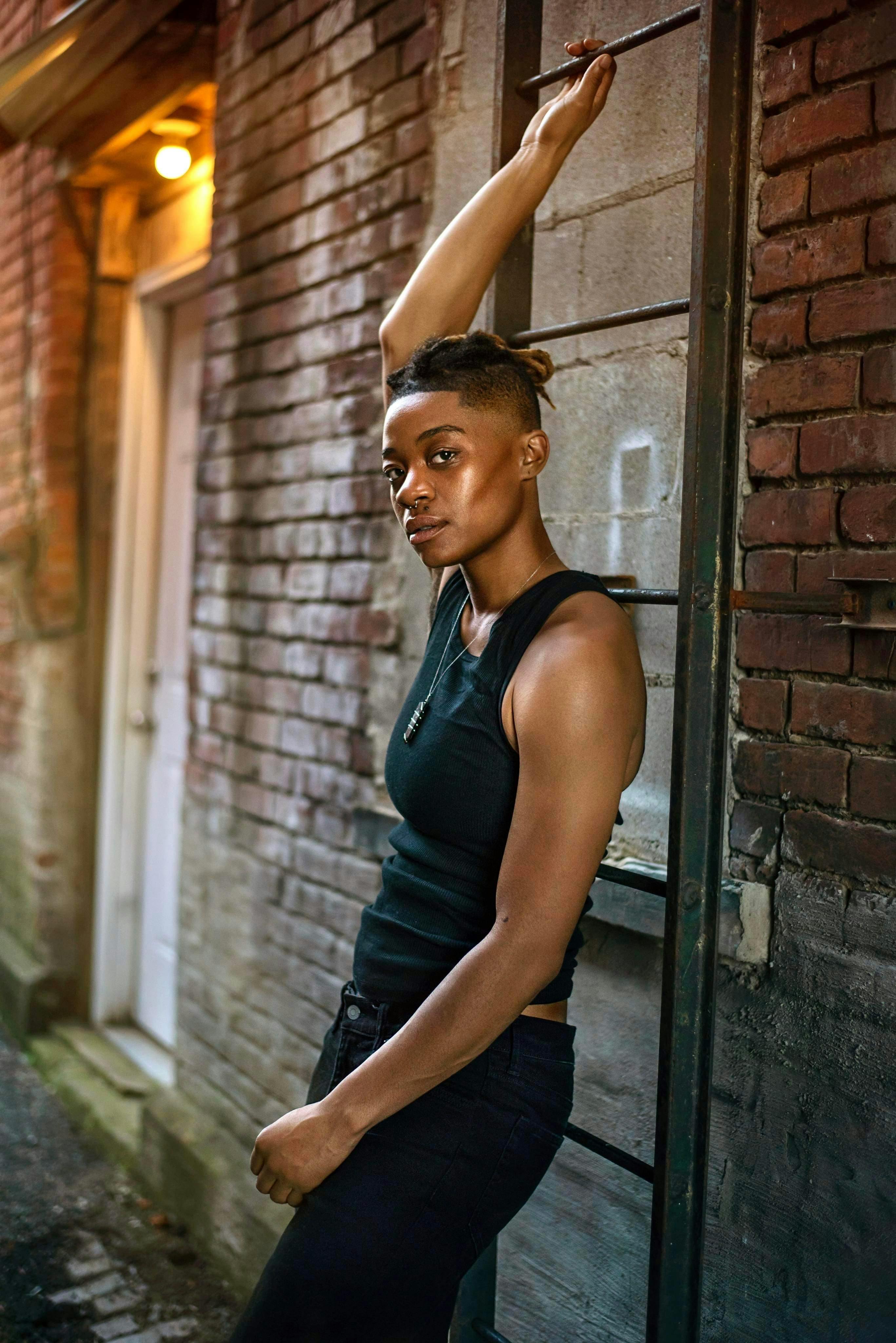 Stylish woman posing in a New York alley, capturing urban fashion vibes.