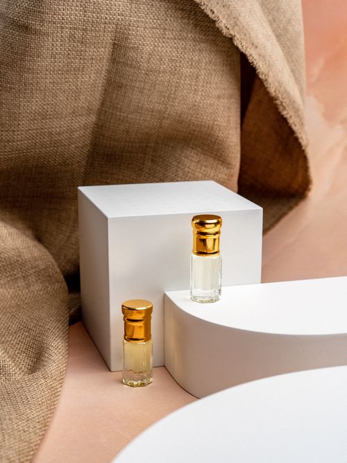 Free Elegant glass perfume bottles displayed on a modern minimalist setup with soft natural lighting. Stock Photo