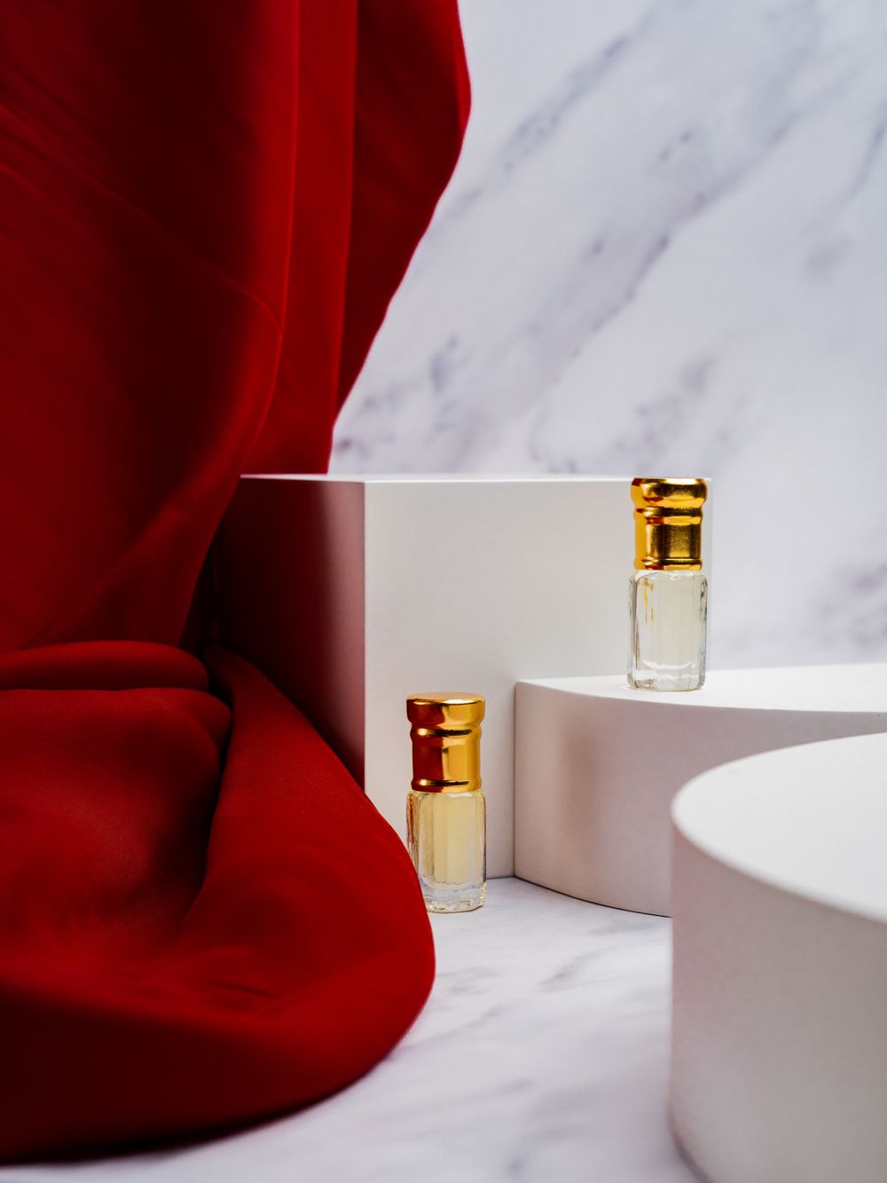 Elegant perfume bottles with golden caps on a marble surface