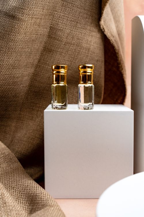 Free Beautiful glass perfume bottles with golden caps on a minimalist display. Stock Photo