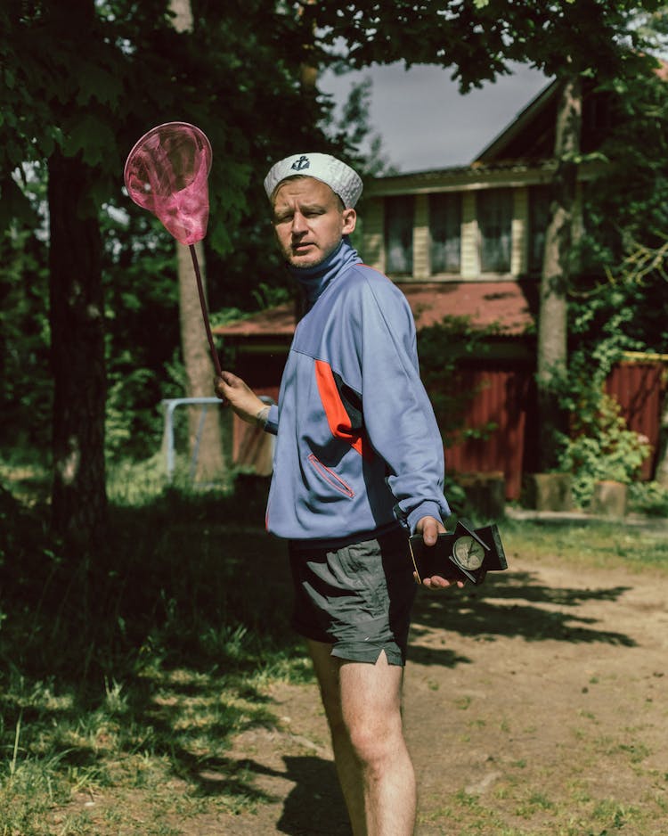 A Man In Blue Jacket Holding A Catching Net