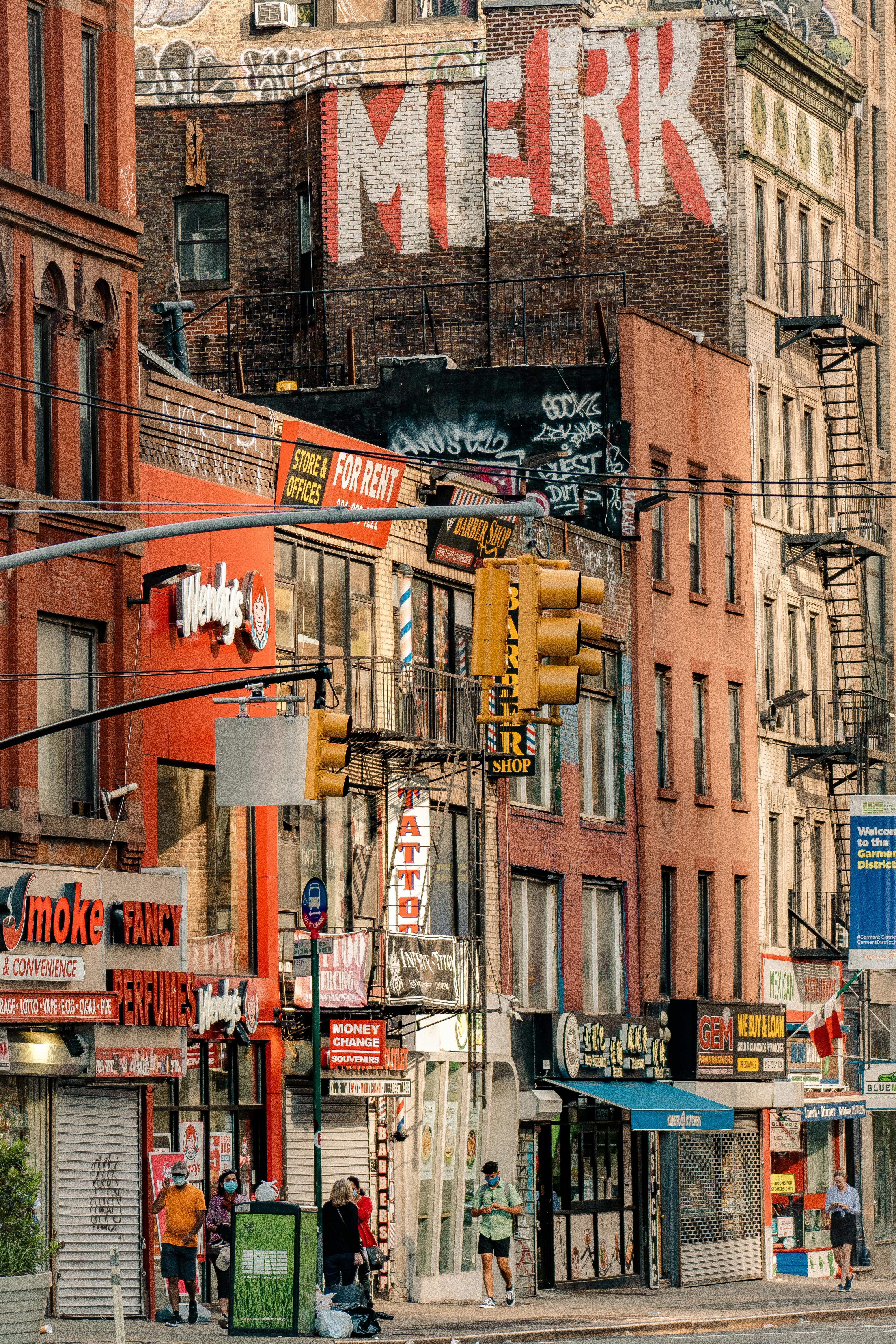 Colorful downtown city scene with graffiti, shops, and walking pedestrians.