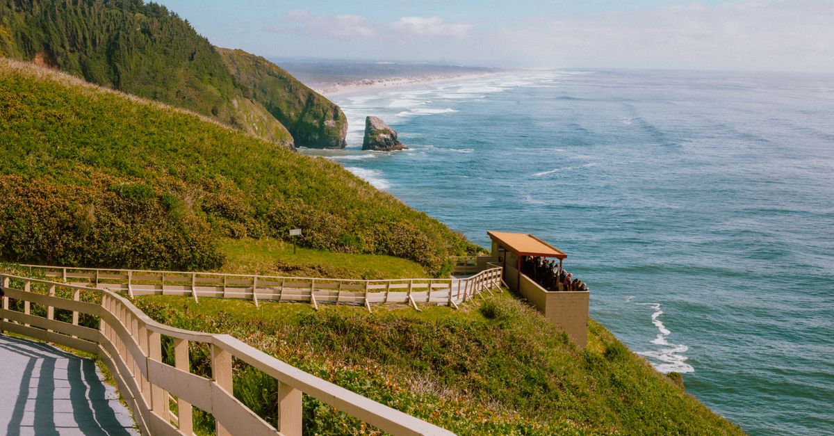 Breathtaking view of the ocean from a cliffside walkway with lush greenery.