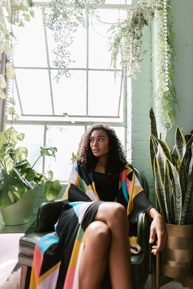 Woman Sitting In Room With Plants