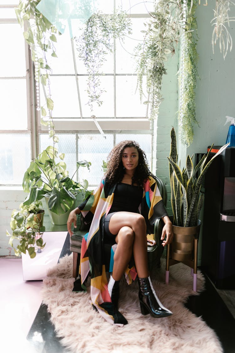 Woman Sitting In Room With Plants