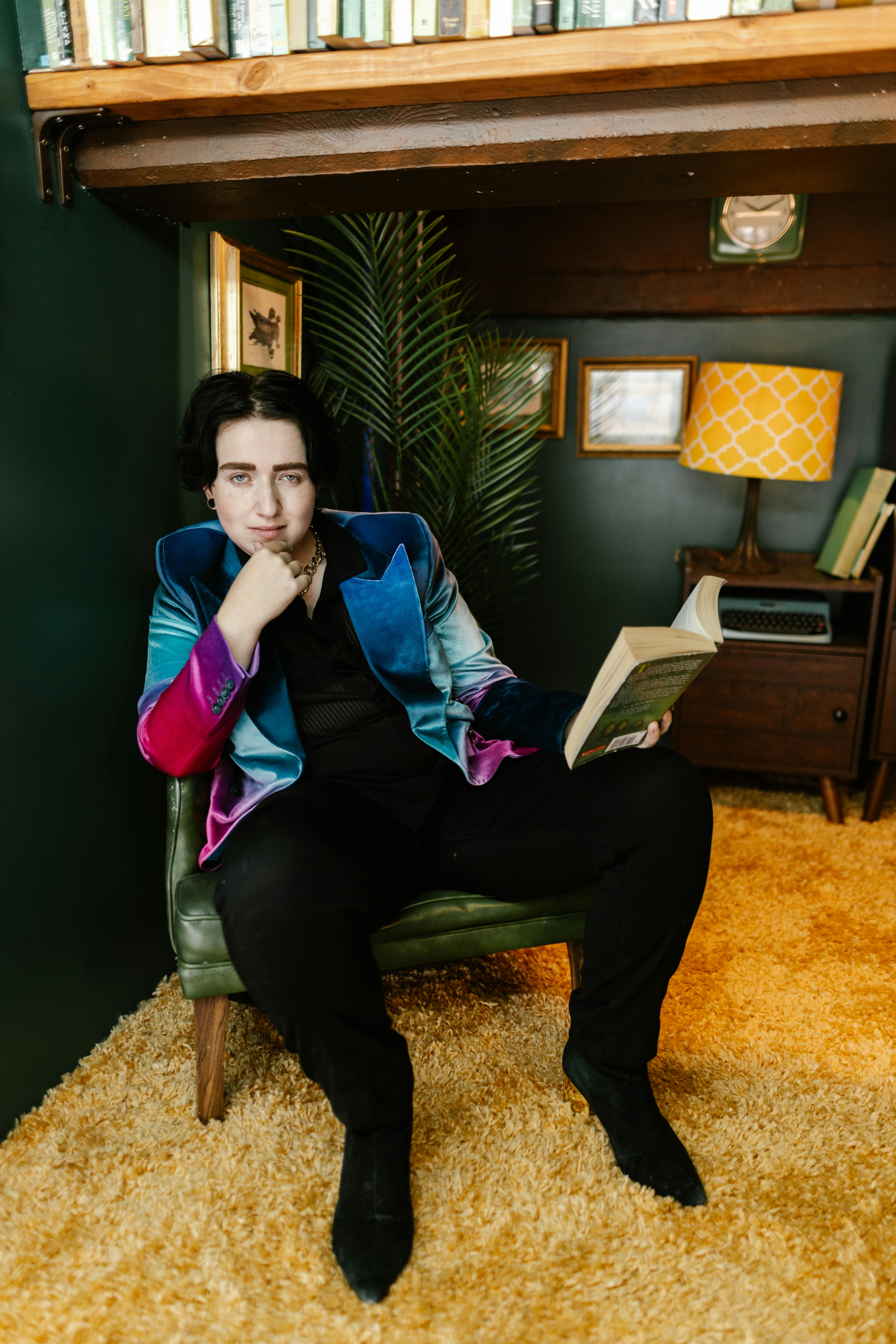 woman sitting on armchair with book