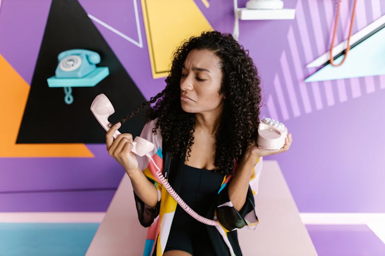 Woman Holding A Vintage Phone And Making A Surprised Face