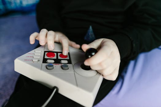 Hands gripping a retro gaming console joystick, showcasing classic gaming technology.