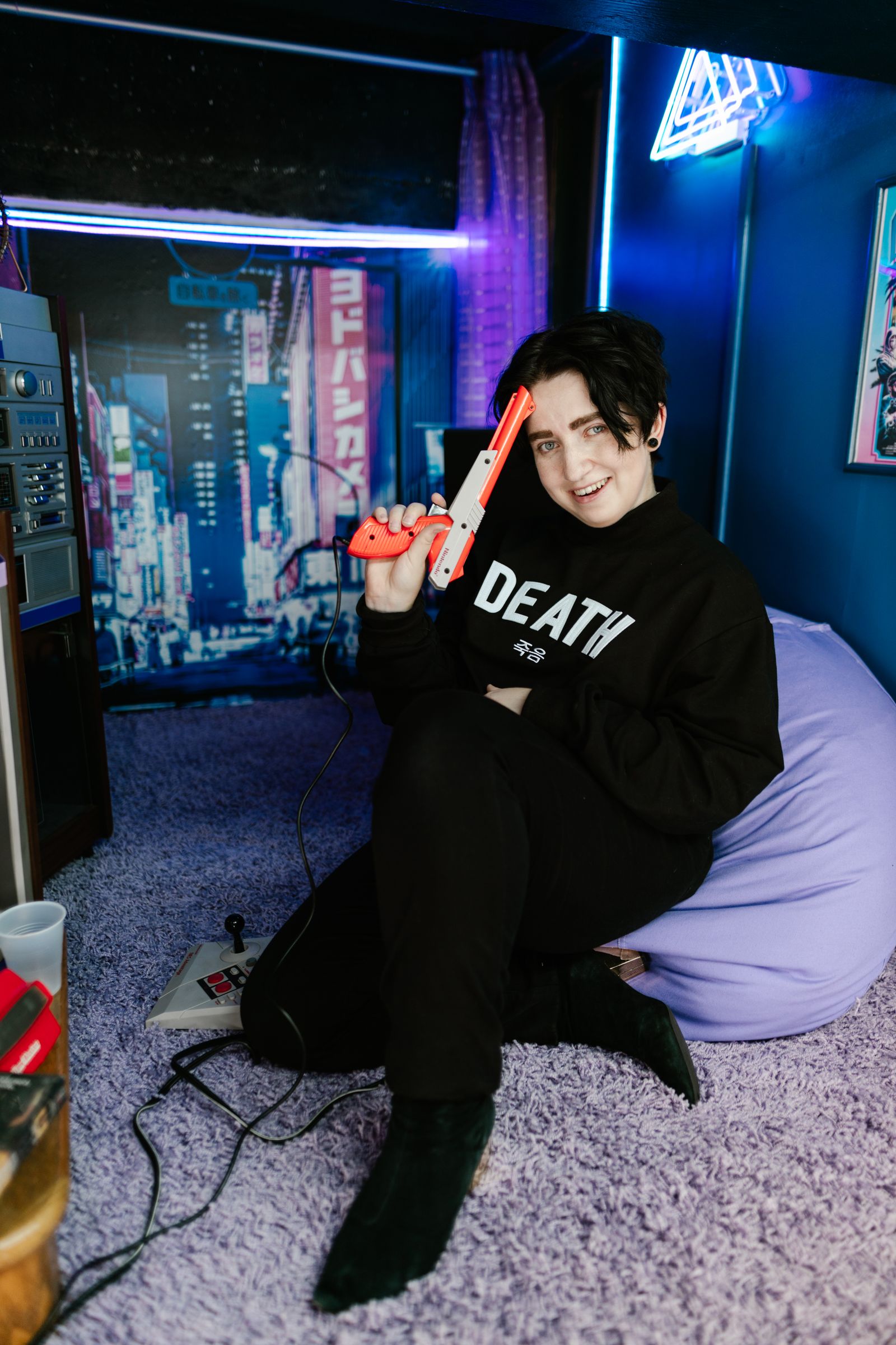 Young gamer holding a controller in neon room