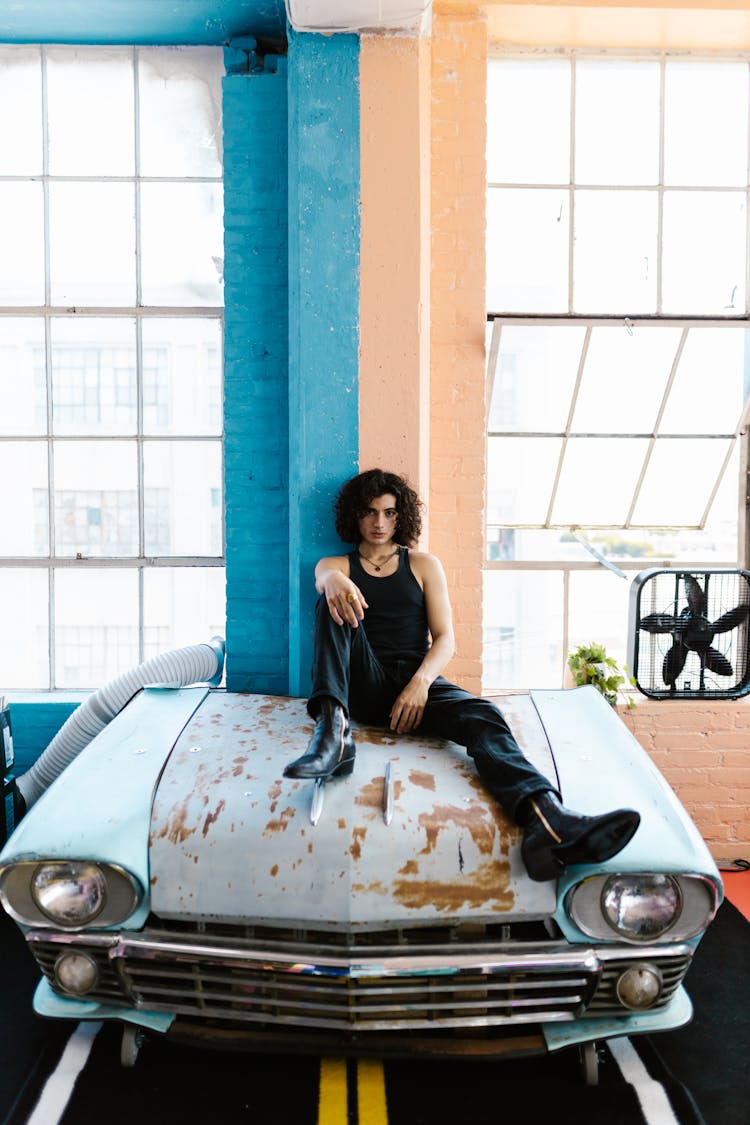 Photo Of A Man On The Hood Of A Car