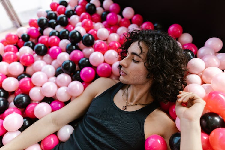 Man Lying In A Pool Of Plastic Balls