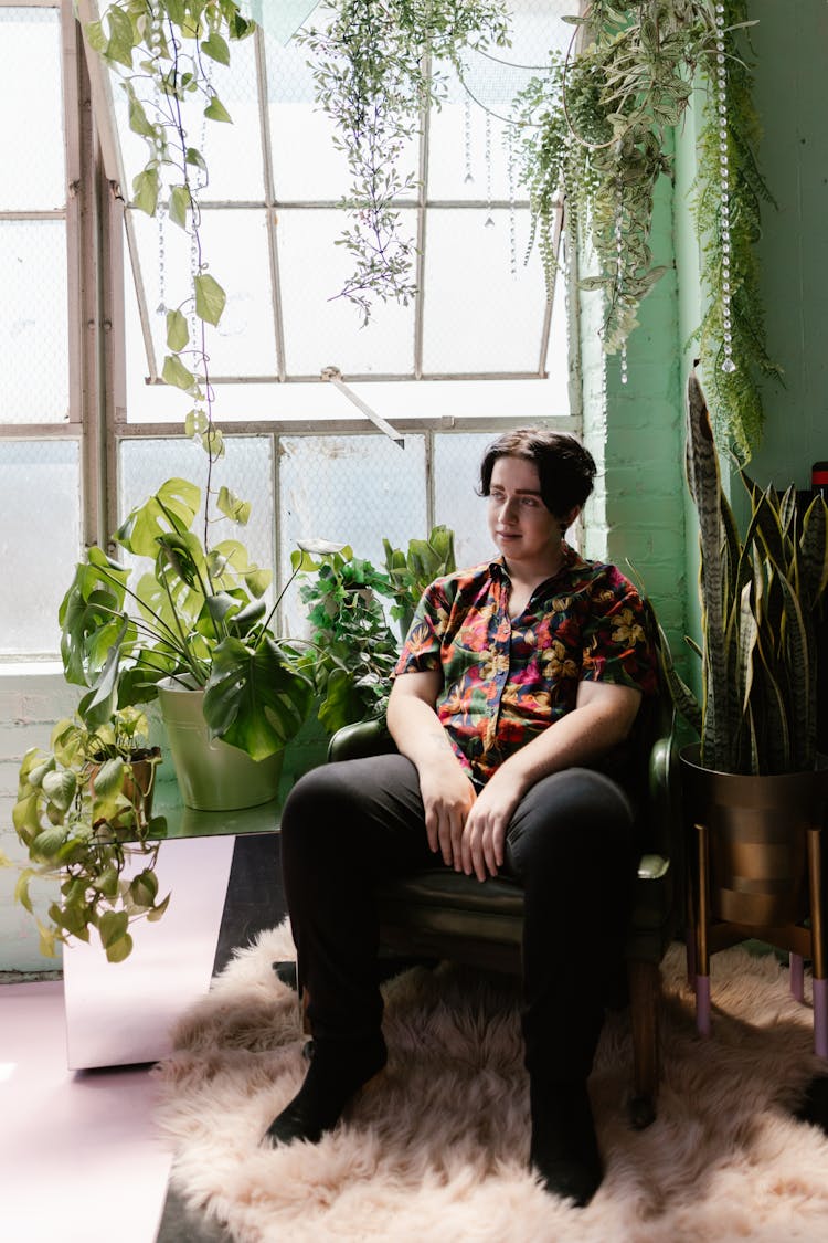 Young Man Sitting In Chair Near Plants