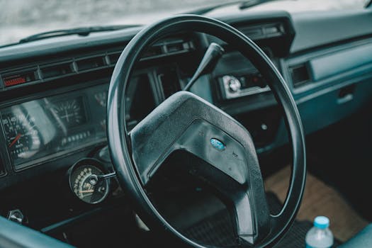 Explore the classic design of a vintage car interior featuring a retro steering wheel and dashboard.