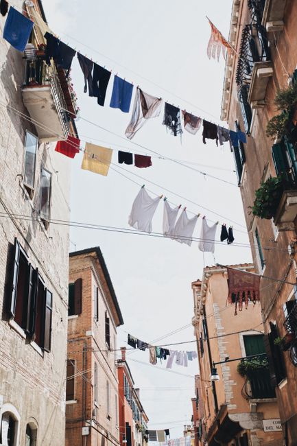 Italian street view with colorful laundry hanging between old buildings.
