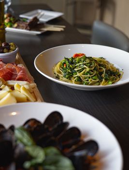 A vibrant selection of Italian dishes including pasta, prosciutto, cheese and seafood displayed on a restaurant table in Toronto.