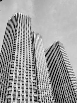 Dramatic black and white capture of towering skyscrapers against a clear sky.