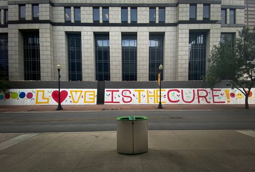 Free Colorful street art mural with 'Love is the Cure' painted on a city building wall. Stock Photo