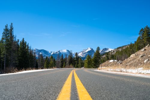 Free Curving road through snow-dusted mountains and pine forests in Colorado's Rockies. Stock Photo