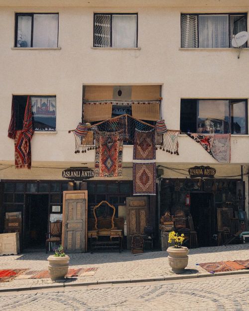 Free Charming antique shop with traditional rugs displayed, capturing a warm vintage aesthetic. Stock Photo