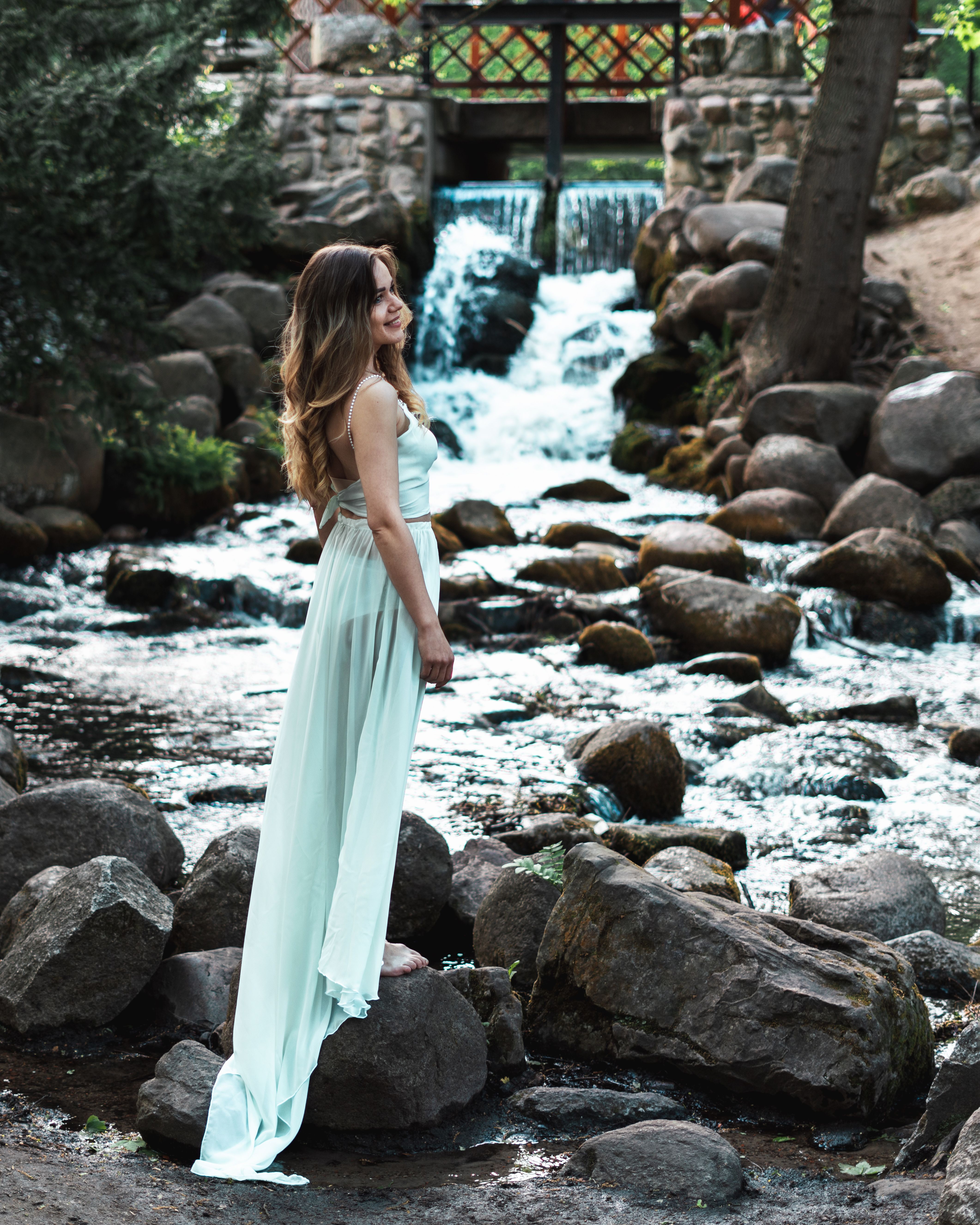 Woman in White Dress Standing on Rocky River · Free Stock Photo