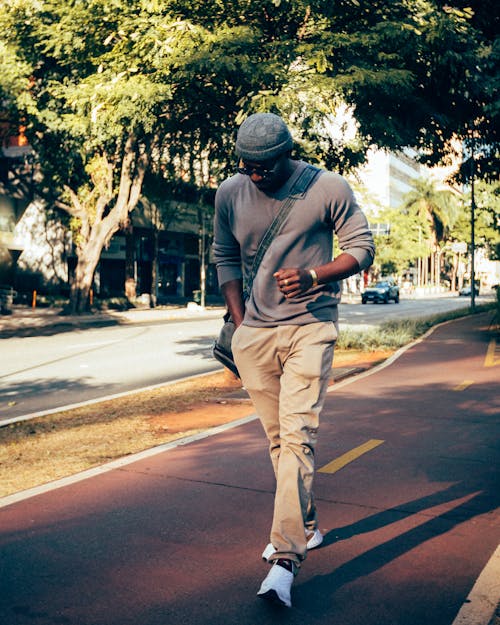 Man in Long Sleeve and Pants Walking on Concrete Pavement