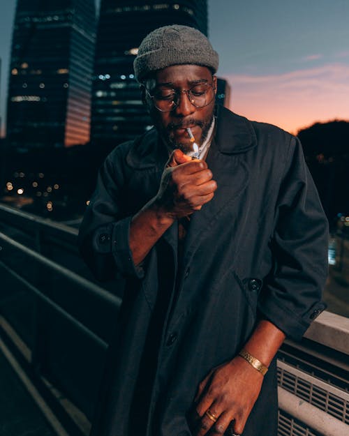 Close-Up Shot of a Man Lighting a Cigarette during Sunset