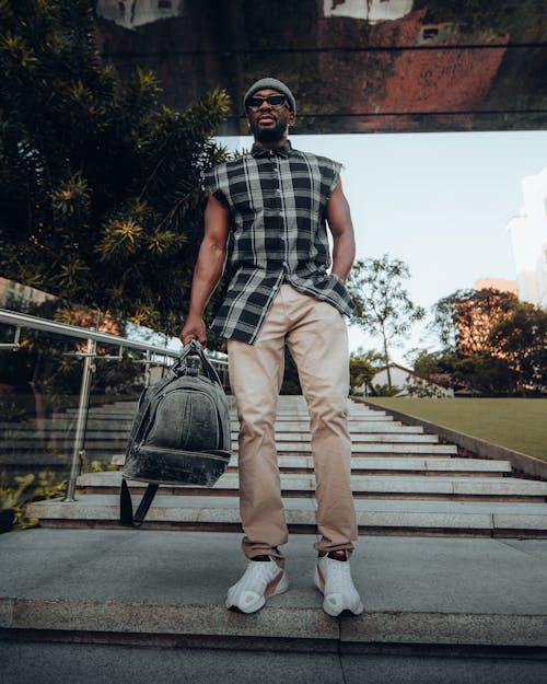 Man in Plaid Shirt and Khaki Pants Holding a Bag