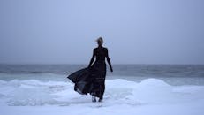 Woman in Black Coat on Frozen Lake