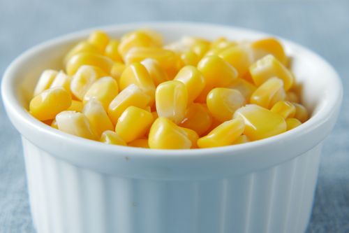 Free Close-up of vibrant yellow corn kernels in a white ceramic bowl, showcasing a healthy snack. Stock Photo