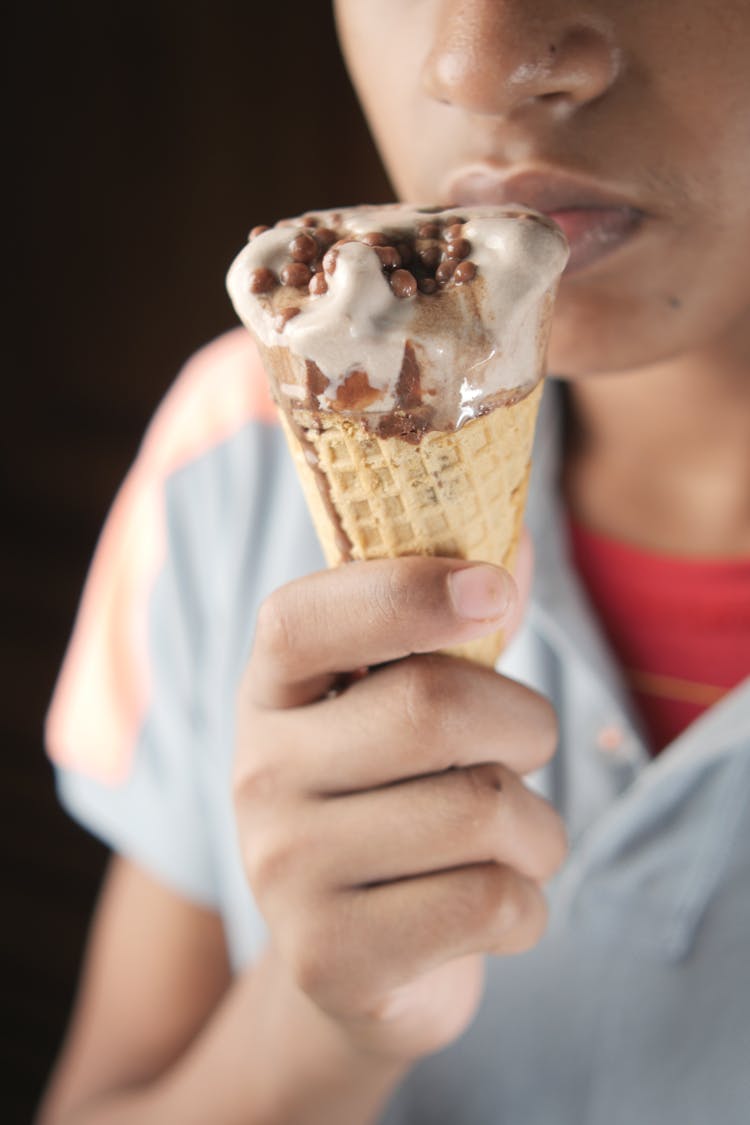 A Person Eating An Ice Cream In Cone