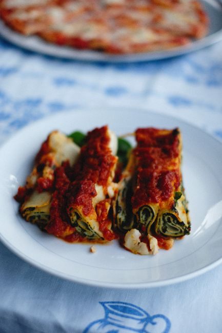 Six ridged manicotti tubes filled with ricotta and spinach, arranged in a baking dish and topped with marinara sauce and melted mozzarella.