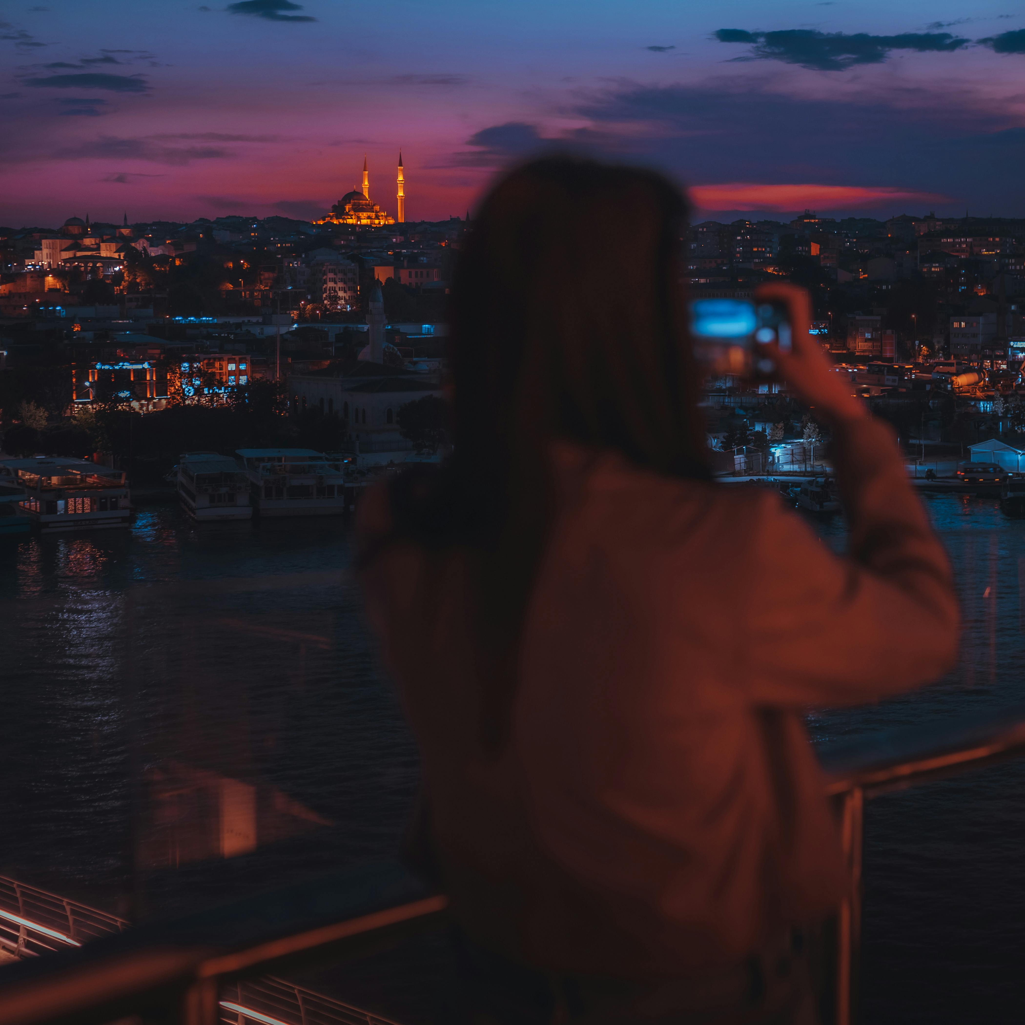 Woman Taking Photo of a City at Night · Free Stock Photo